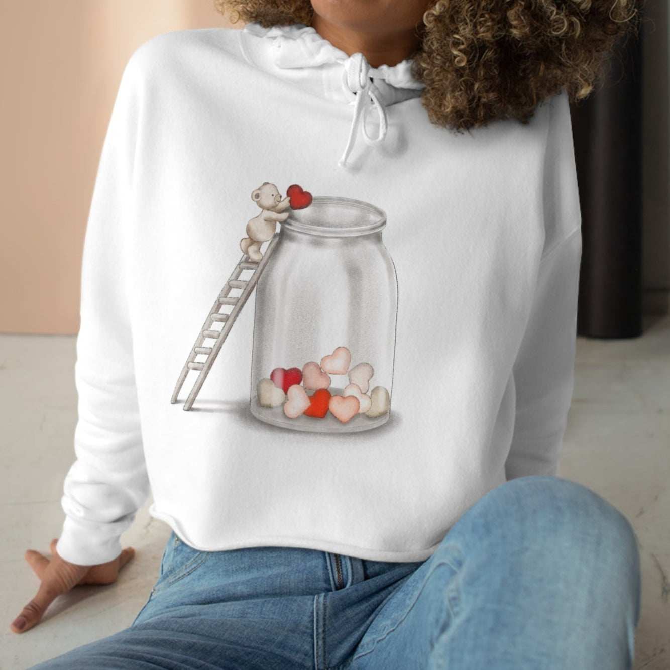 Cropped hoodie for women with heart jar graphic, soft fleece, and raw hem.